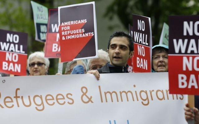 In this May 15, 2017, file photo, protesters hold signs during a demonstration against President Donald Trump's revised travel ban, Monday, May 15, 2017, outside a federal courthouse in Seattle. (AP Photo/Ted S. Warren, file) In this May 15, 2017, file photo, protesters hold signs during a demonstration against President Donald Trump's revised travel ban, Monday, May 15, 2017, outside a federal courthouse in Seattle. (AP Photo/Ted S. Warren, file)