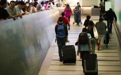 Travelers make their way up the arrival ramp at the Tom Bradley International Terminal at the Los Angeles International Airport Thursday, June 29, 2017, in Los Angeles (AP Photo/Jae C. Hong)