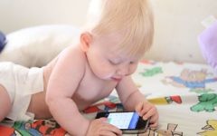 Illustrative photo of a baby playing with an iPhone. (Chen Leopold/flash90)