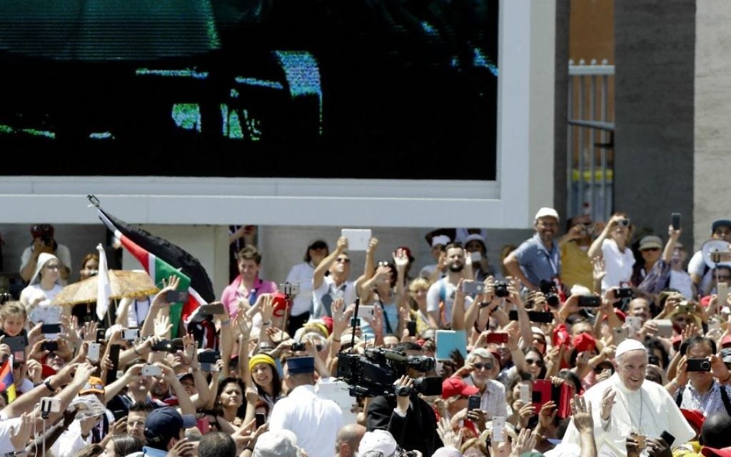 Pope Francis, bottom right, is driven through the crowd as his image is projected on a giant screen, in St. Peter's Square, at the Vatican, Sunday, June 4, 2017. (AP Photo/Gregorio Borgia)
