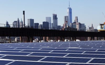 In this February 14, 2017 photo, taken against the backdrop of the Manhattan skyline, a rooftop is covered with solar panels at the Brooklyn Navy Yard in New York. (AP Photo/Mark Lennihan)