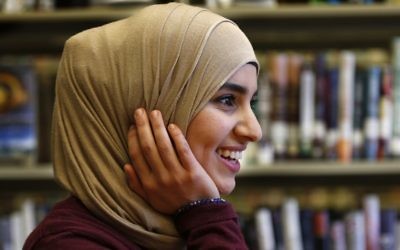 In this June 1, 2017, photo Israa Enan wears a stylish hijab during an interview at Deering High School in Portland, Maine. Enan, who recently graduated, admitted she shied away from going out for high school sports teams because of the embarrassment she would have felt if her stylish scarf fell off during competition. (AP Photo/Robert F. Bukaty)