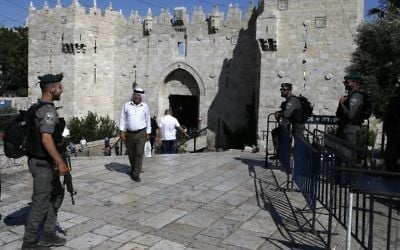A Palestinian man walks past Israeli security forces standing guard at Damascus Gate outside Jerusalem's Old City on May 31, 2017. (AFP Photo/Ahmad Gharabli) A Palestinian man walks past Israeli security forces standing guard at Damascus Gate outside Jerusalem's Old City on May 31, 2017. (AFP Photo/Ahmad Gharabli)