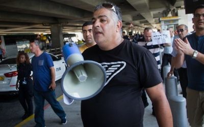 Taxis drivers demonstrate at Ben Gurion Airport outside of Tel Aviv against the airport's planned 12% reduction in cab fares, June 12, 2017. The placard says 'no discount.' (FLASH90)