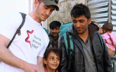 A volunteer with the organization World Jewish Relief works with refugees in Greece. (Minos Alchanati/via JTA)