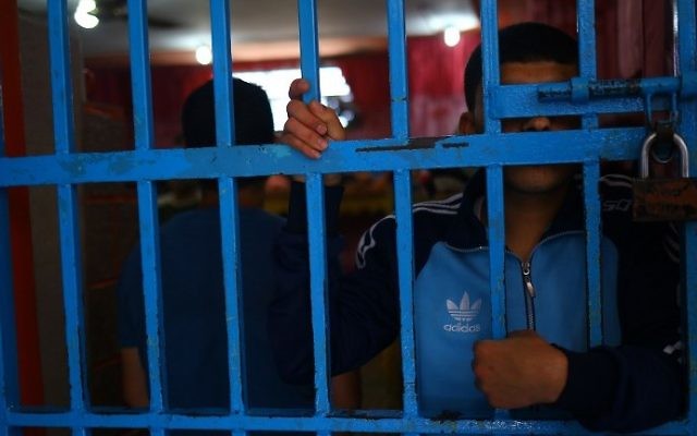 Illustrative: A prisoner behind bars at a Hamas-run prison in Gaza City on May 10, 2017. (AFP Photo/Mohammed Abed) Illustrative: A prisoner behind bars at a Hamas-run prison in Gaza City on May 10, 2017. (AFP Photo/Mohammed Abed)