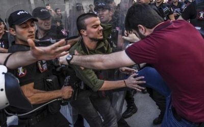 A plain-clothes police officer kicks a member of a group of LGBT rights activist as Turkish police prevent them from going ahead with a Gay Pride annual parade on June 25, 2017, in Istanbul. (AFP Photo/Bulent Kilic)