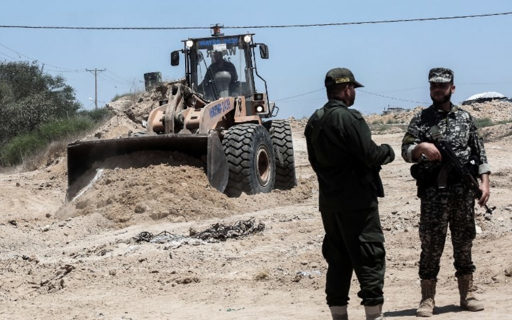 Security forces loyal to the Hamas terror group stand by as bulldozers clear an area for a large buffer zone on the border with Egypt in the southern Gaza strip town of Rafah, on June 28, 2017. (AFP/Said Khatib)