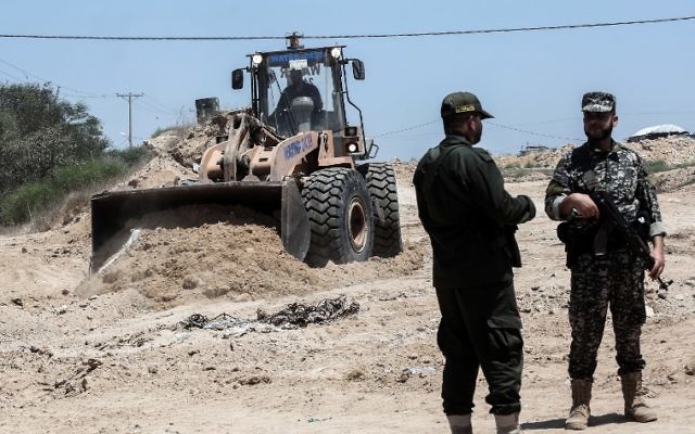 Security forces loyal to the Hamas terror group stand by as bulldozers clear an area for a large buffer zone on the border with Egypt in the southern Gaza strip town of Rafah, on June 28, 2017. (AFP/Said Khatib) Security forces loyal to the Hamas terror group stand by as bulldozers clear an area for a large buffer zone on the border with Egypt in the southern Gaza strip town of Rafah, on June 28, 2017. (AFP/Said Khatib)