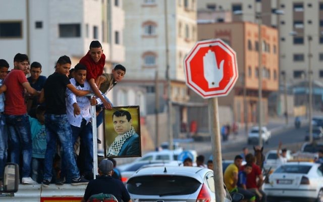Palestinian youths hold a framed portrait of Mohammed Dahlan, an exiled senior Fatah official and rival to Mahmoud Abbas, who was sentenced in absentia to three years in prison on corruption charges, on June 29, 2017. (AFP PHOTO / MOHAMMED ABED) Palestinian youths hold a framed portrait of Mohammed Dahlan, an exiled senior Fatah official and rival to Mahmoud Abbas, who was sentenced in absentia to three years in prison on corruption charges, on June 29, 2017. (AFP PHOTO / MOHAMMED ABED)