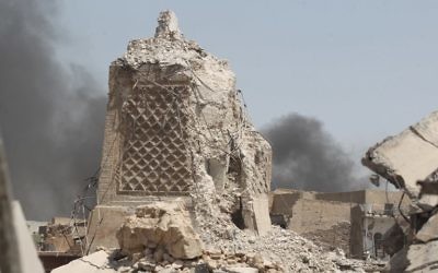 Smoke billows in the background behind the base of Mosul's destroyed ancient leaning minaret, known as the "Hadba" (Hunchback), in the Old City on June 30, 2017, where Abu Bakr al-Baghdadi gave his first sermon as leader of the Islamic State group and its ancient minaret. (AFP PHOTO / AHMAD AL-RUBAYE)