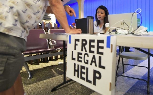 Volunteer lawyer Marwa Rifahie, a civil rights attorney with the Council on American-Islamic Relations, responds to questions from behind a at a table set up at Los Angeles International Airport in Los Angeles, California on June 30, 2017, offering free legal advice. (AFP PHOTO / FREDERIC J. BROWN)