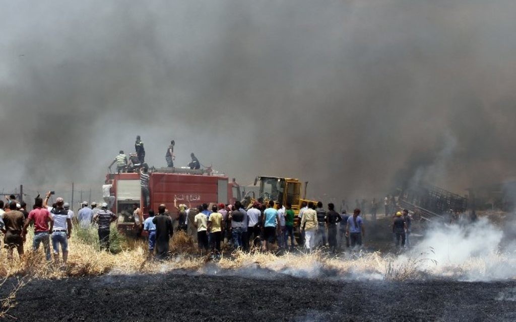 Smoke billows as firefighters attempt to extinguish a massive fire in a camp for Syrian refugees near the village of Qab Elias in the Lebanese Bekaa valley on July 2, 2017. (AFP PHOTO / STRINGER)