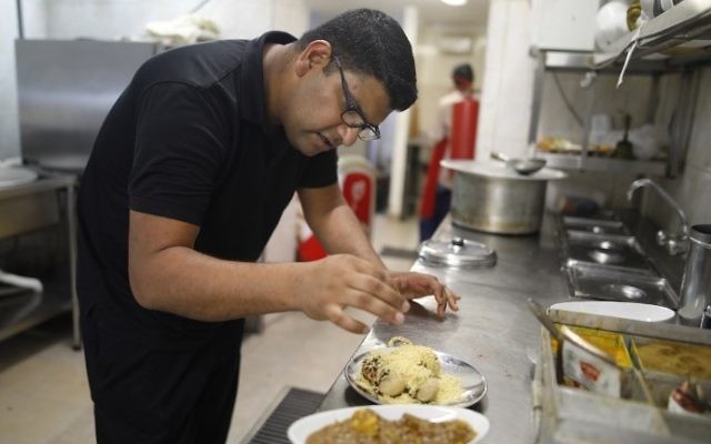 Elazar Ashtivker, owner of the Maharaja Indian restaurant in the small city of Ramla, south of Tel Aviv, cooks at his restaurant on July 2, 2017, as the Jewish Indian community prepare for the visit of the Indian prime minister. (AFP/ MENAHEM KAHANA) 