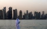 A man looks at his phone on the corniche in the Qatari capital Doha, on July 2, 2017. (AFP Photo/STR)