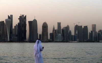 A man looks at his phone on the corniche in the Qatari capital Doha on July 2, 2017. (AFP Photo/STR)