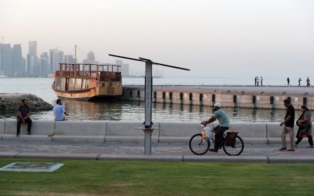 People walk on the corniche of the Qatari capital Doha on July 2, 2017. (AFP/ STR) People walk on the corniche of the Qatari capital Doha on July 2, 2017. (AFP/ STR)