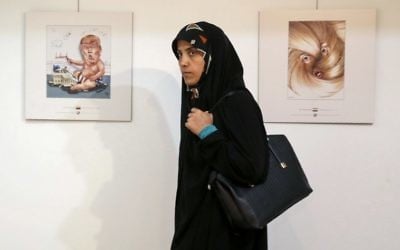 An Iranian woman looks at cartoons of US President Donald Trump at an exhibition of the Islamic Republic's 2017 International Trumpism cartoon and caricature contest in Tehran, July 3, 2017. (AFP/ATTA KENARE)