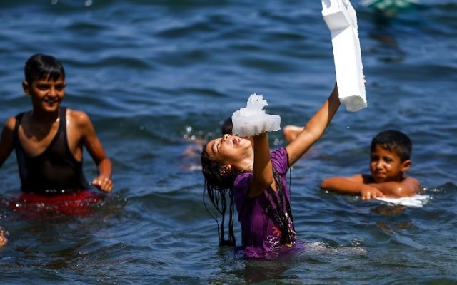 A Palestinian girl laughs while holding a jellyfish in one hand a block of foam in another, as she stands in the Mediterranean sea near al-Shati refugee camp in Gaza City on July 3, 2017. ( AFP PHOTO / MOHAMMED ABED) A Palestinian girl laughs while holding a jellyfish in one hand a block of foam in another, as she stands in the Mediterranean sea near al-Shati refugee camp in Gaza City on July 3, 2017. ( AFP PHOTO / MOHAMMED ABED)