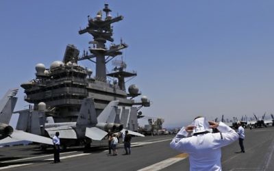 A soldier walks on the deck of the US aircraft carrier USS George H. W. Bush, as it docks outside Haifa port, on July 3, 2017. (AFP Photo/AFP Photo and Pool/Ronen Zvulun)