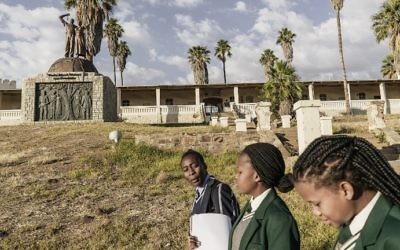 Namibian schoolgirls walk by a memorial in tribute to the victims of the alleged genocide committed by German forces against Herero and Nama people in 1904, on June 20, 2017 in Windhoek, Namibia. (AFP Photo/Gianluigi Guercia)