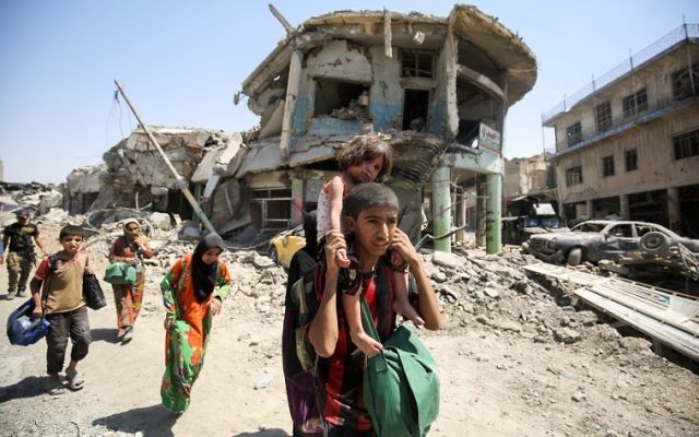 An Iraqi boy carries a girl on his back while fleeing from the Old City of Mosul on July 5, 2017, during the Iraqi government forces' offensive to retake the city from Islamic State (IS) group fighters. (AFP PHOTO / AHMAD AL-RUBAYE) An Iraqi boy carries a girl on his back while fleeing from the Old City of Mosul on July 5, 2017, during the Iraqi government forces' offensive to retake the city from Islamic State (IS) group fighters. (AFP PHOTO / AHMAD AL-RUBAYE)