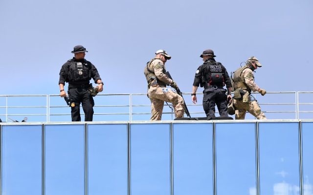 Policemen and soldiers stand on a roof to secure the area as the US President meets with Baltic, Balkan and central European leaders during the Three Seas Initiative Summit in Warsaw, Poland, July 6, 2017. (AFP/JANEK SKARZYNSKI)