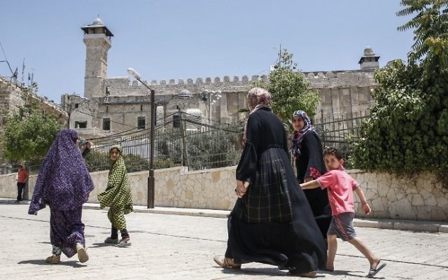 A picture taken on July 7, 2017 shows Palestinians walking by outside the Tomb of the Patriarchs in the West Bank city of Hebron. (AFP/Hazem Bader) A picture taken on July 7, 2017 shows Palestinians walking by outside the Tomb of the Patriarchs in the West Bank city of Hebron. (AFP/Hazem Bader)