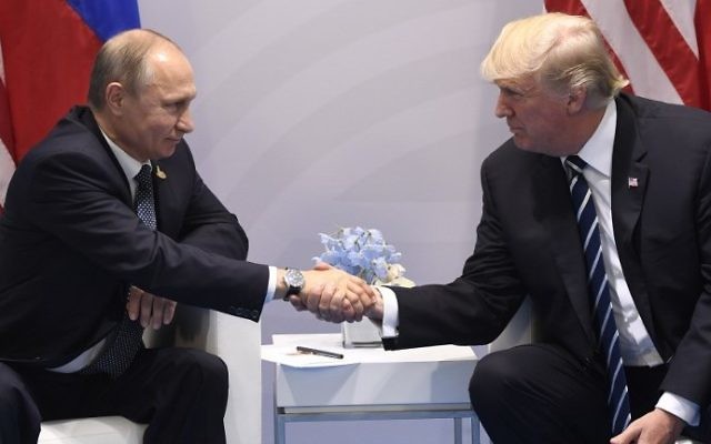 US President Donald Trump and Russia's President Vladimir Putin shake hands during a meeting on the sidelines of the G20 Summit in Hamburg, Germany, on July 7, 2017. (AFP PHOTO / SAUL LOEB)