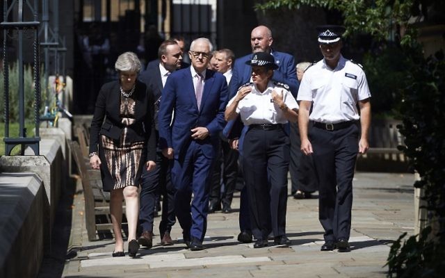 Britain's Prime Minister Theresa May, left, Australian Prime Minister, Malcolm Turnbull, center, and police officials walk outside Southwark cathedral during a visit to the Borough Market area of London in central London on July 10, 2017, the scene of a June 3 terror attack. (AFP/ POOL / Niklas HALLEN)