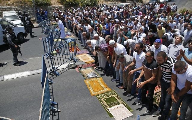 Muslim worshippers pray on a street outside the Lions Gate near Jerusalem's Temple Mount on July 14, 2017, after three Arab Israelis assailants killed two Israeli police officers there (AFP PHOTO / AHMAD GHARABLI)