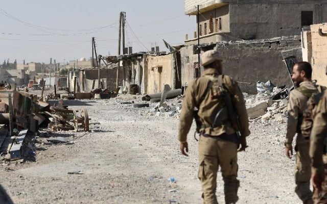 Members of the Syrian Democratic Forces (SDF), an alliance of Kurdish and Arab fighters, walk along a damaged street in eastern Raqqa, Syria, July 14, 2017.
(AFP/Bulent Kilic) Members of the Syrian Democratic Forces (SDF), an alliance of Kurdish and Arab fighters, walk along a damaged street in eastern Raqqa, Syria, July 14, 2017.
(AFP/Bulent Kilic)