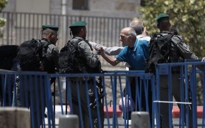 A Palestinian man speaks with an Israeli border police standing guard outside Damascus Gate, a main entrance to Jerusalem's Old City, on July 15, 2017 (AFP PHOTO / AHMAD GHARABLI)
