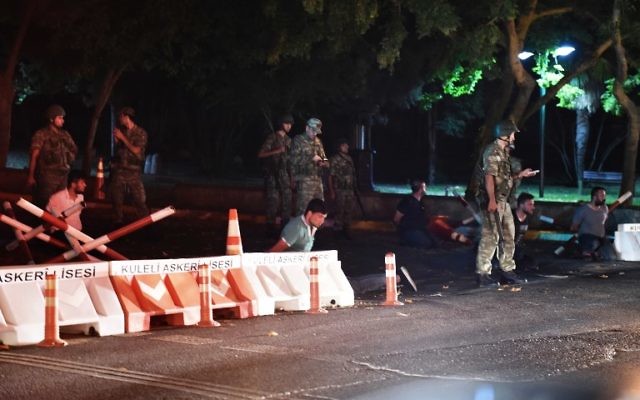 This file photo taken on July 15, 2016 shows Turkish security officers detaining police officers on the side of the road in Istanbul, during a security shutdown of the Bosphorus Bridge. (AFP PHOTO / BULENT KILIC)