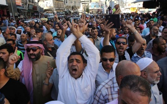 Protesters chant slogans in the Jordanian capital Amman on July 15, 2017 during a demonstration against the closure of the Al-Aqsa mosque compound in Jerusalem, which Israeli security forces closed a day earlier after Arab gunmen killed two Israeli policemen in the Holy City. (AFP PHOTO / KHALIL MAZRAAWI) Protesters chant slogans in the Jordanian capital Amman on July 15, 2017 during a demonstration against the closure of the Al-Aqsa mosque compound in Jerusalem, which Israeli security forces closed a day earlier after Arab gunmen killed two Israeli policemen in the Holy City. (AFP PHOTO / KHALIL MAZRAAWI)