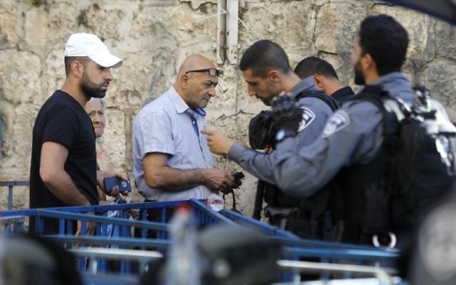 Israeli border policemen inspect the documents of Palestinians in Jerusalem's Old City, on July 16, 2017. (AFP PHOTO / Menahem KAHANA) Israeli border policemen inspect the documents of Palestinians in Jerusalem's Old City, on July 16, 2017. (AFP PHOTO / Menahem KAHANA)