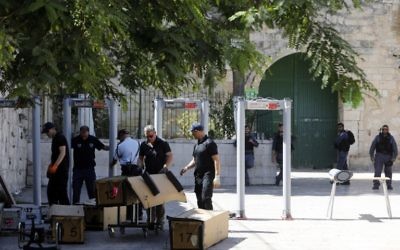 Israeli border policemen install metal detectors outside the Lions' Gate, a main entrance to Al-Aqsa mosque compound, in Jerusalem's Old City, on July 16, 2017. (AFP PHOTO / Menahem KAHANA)