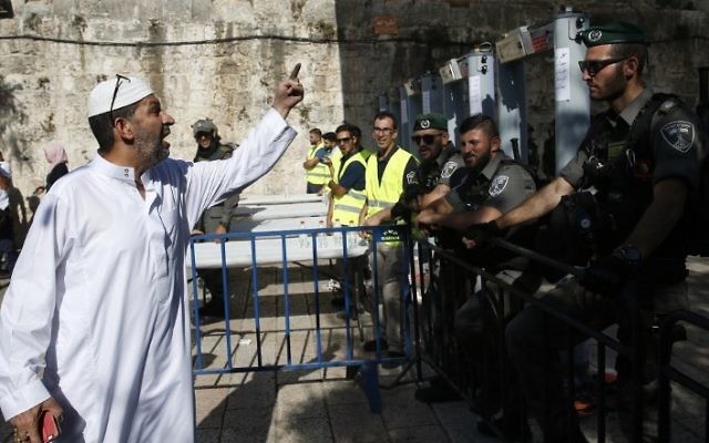 A Palestinian man argues with Israeli border policemen standing guard near newly installed metal detectors at a main entrance to the Temple Mount, on July 16, 2017. (AFP/Ahmad Gharabli) A Palestinian man argues with Israeli border policemen standing guard near newly installed metal detectors at a main entrance to the Temple Mount, on July 16, 2017. (AFP/Ahmad Gharabli)