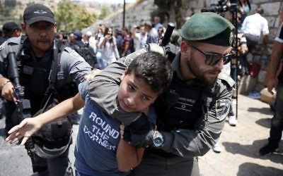 Israeli border guards detain a protester during a demonstration outside the Lions Gate in Jerusalem's Old City on July 17, 2017. (AFP Photo/Ahmad Gharabli) Israeli border guards detain a young protester during a demonstration outside the Lions Gate in Jerusalem's Old City on July 17, 2017. (AFP Photo/Ahmad Gharabli)