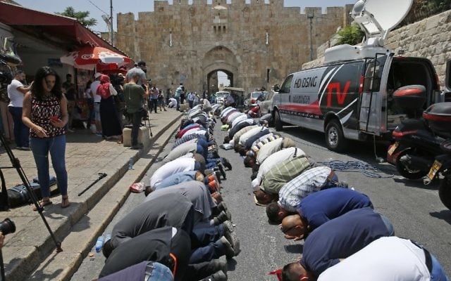 Muslim worshipers who refuse to enter the Temple Mount due to newly implemented security measures by Israeli authorities pray outside the Lions Gate in Jerusalem's Old City on July 17, 2017. (AFP/AHMAD GHARABLI) Muslim worshipers who refuse to enter the Temple Mount due to newly implemented security measures by Israeli authorities pray outside the Lions Gate in Jerusalem's Old City on July 17, 2017. (AFP/AHMAD GHARABLI)
