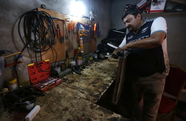 Haitham Behnam, a 34-year-old Iraqi Christian man who fled the violence in Mosul after Islamic State (IS) group militants seized control of the northern Iraqi city, works at his auto repair workshop in Arbil, the capital of the autonomous Kurdish region of northern Iraq, on July 20, 2017. (AFP PHOTO / SAFIN HAMED) Haitham Behnam, a 34-year-old Iraqi Christian man who fled the violence in Mosul after Islamic State (IS) group militants seized control of the northern Iraqi city, works at his auto repair workshop in Arbil, the capital of the autonomous Kurdish region of northern Iraq, on July 20, 2017. (AFP PHOTO / SAFIN HAMED)