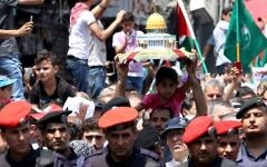 Jordanians carry a model of the Dome of the Rock shrine during a demonstration, called for by the Islamic Action Front, in Amman following friday prayers on July 21, 2017, to protest against new Israeli security measures implemented at the holy site, which include metal detectors and cameras, following an attack that killed two Israeli policemen the previous week. (AFP/Khalil Mazraawi)