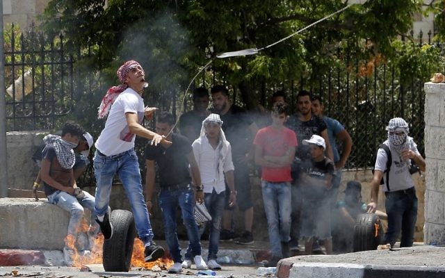 A Palestinian protester releases a stone from a slingshot towards Israeli forces during clashes after Friday prayers at the main entrance of the West Bank city of Bethlehem on July 21, 2017. (AFP/Musa Al Shaer) A Palestinian protester releases a stone from a slingshot towards Israeli forces during clashes after Friday prayers at the main entrance of the West Bank city of Bethlehem on July 21, 2017. (AFP/Musa Al Shaer)