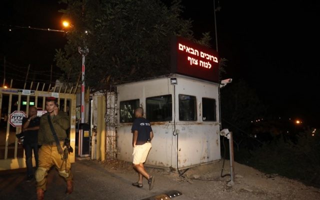 An Israeli soldier stands guard at the gated entrance of the Halamish settlement, on July 22, 2017, a day after a Palestinian terrorist killed three Israelis there. (AFP PHOTO / GALI TIBBON)