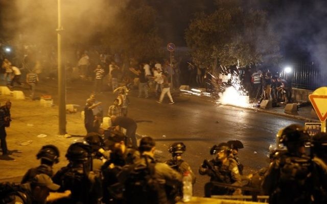 Border Police fire a stun grenade in an attempt to disperse Palestinian Muslim worshipers outside the Old City of Jerusalem's Lions Gate on July 22, 2017. (AFP Photo/Ahmad Gharabli)