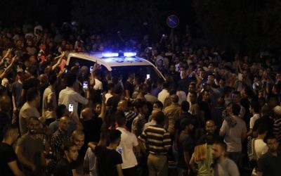 Palestinian demonstrators attempt the block the road ahead of Israeli police cars outside Lions' Gate, a main entrance to the Temple Mount compound in Jerusalem's Old City, July 22, 2017. (AFP/Ahmad GHARABLI)