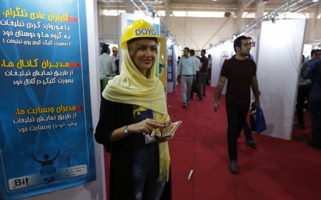 A hostess welcomes visitors during the Elecomp tech fair in the Iranian capital Tehran, July 23, 2017. (AFP/ATTA KENARE) A hostess welcomes visitors during the Elecomp tech fair in the Iranian capital Tehran, July 23, 2017. (AFP/ATTA KENARE)