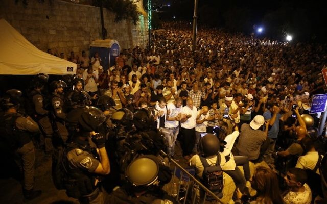 Israeli security forces stand by, as Palestinian Muslim worshipers pray outside the Temple Mount in Jerusalem's Old City, on July 23, 2017. (AFP PHOTO / AHMAD GHARABLI) Israeli security forces stand by, as Palestinian Muslim worshipers pray outside the Temple Mount in Jerusalem's Old City, on July 23, 2017. (AFP PHOTO / AHMAD GHARABLI)