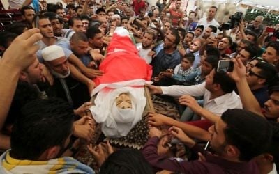 Mourners carry the body of 17-year-old Mohammed Jawawdeh, who was killed on the weekend when he attacked a security guard at the Israeli embassy compound in the Jordanian capital with a screwdriver, during his funeral in Amman on July 25, 2017. (Khalil Mazraawi/AFP)