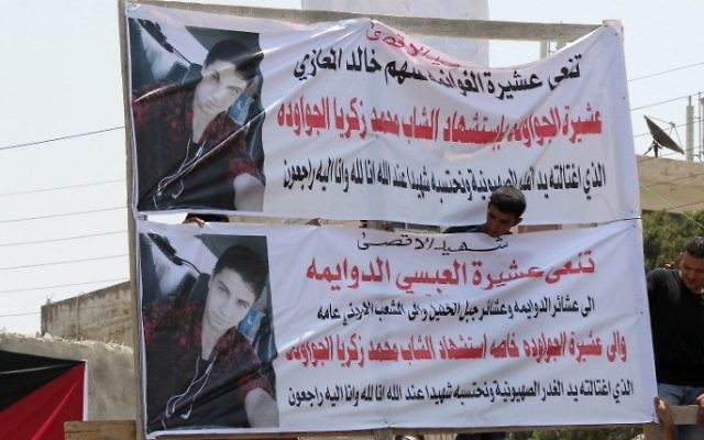 Mourners erect banners bearing the portrait of 17-year-old Mohammed Jawawdeh, who was killed on the weekend when he attacked a security guard at the Israeli embassy compound in the Jordanian capital with a screwdriver, during his funeral in Amman on July 25, 2017. (Khalil Mazraawi/AFP)